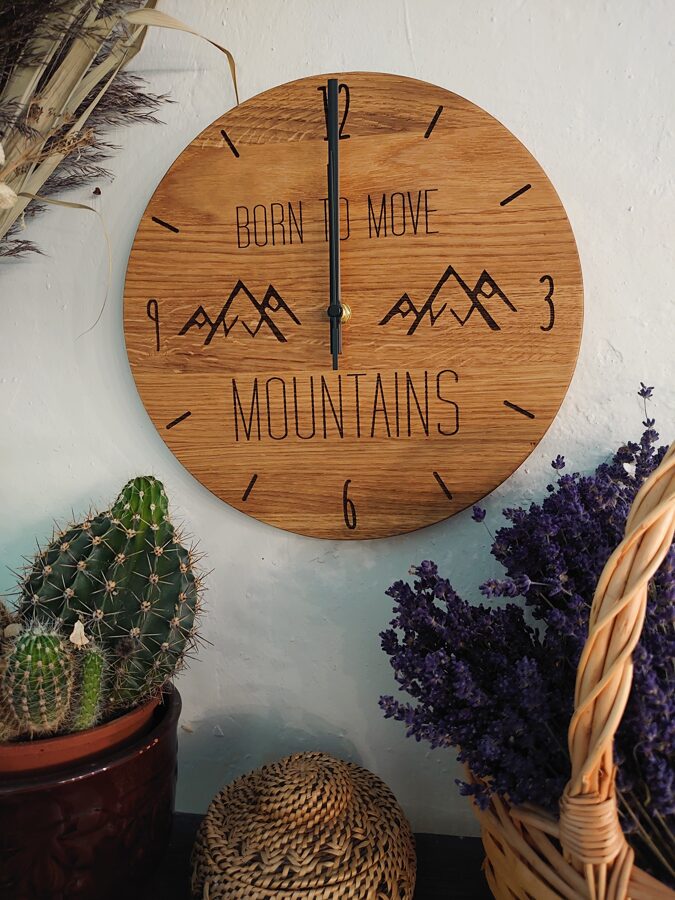 Koka sienas pulkstenis ar gravējumu - Born to move mountains